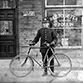 Police Officer with bicycle in front of C. Poulin's store, 324 Rochester Street, ca/ 1900